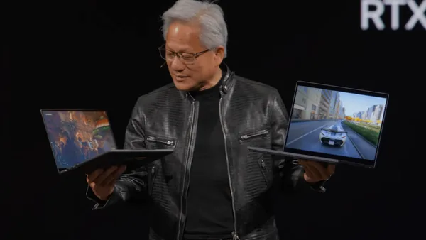Nvidia CEO Jensen Huang holds up two RTX Spark laptops at Computex 2026