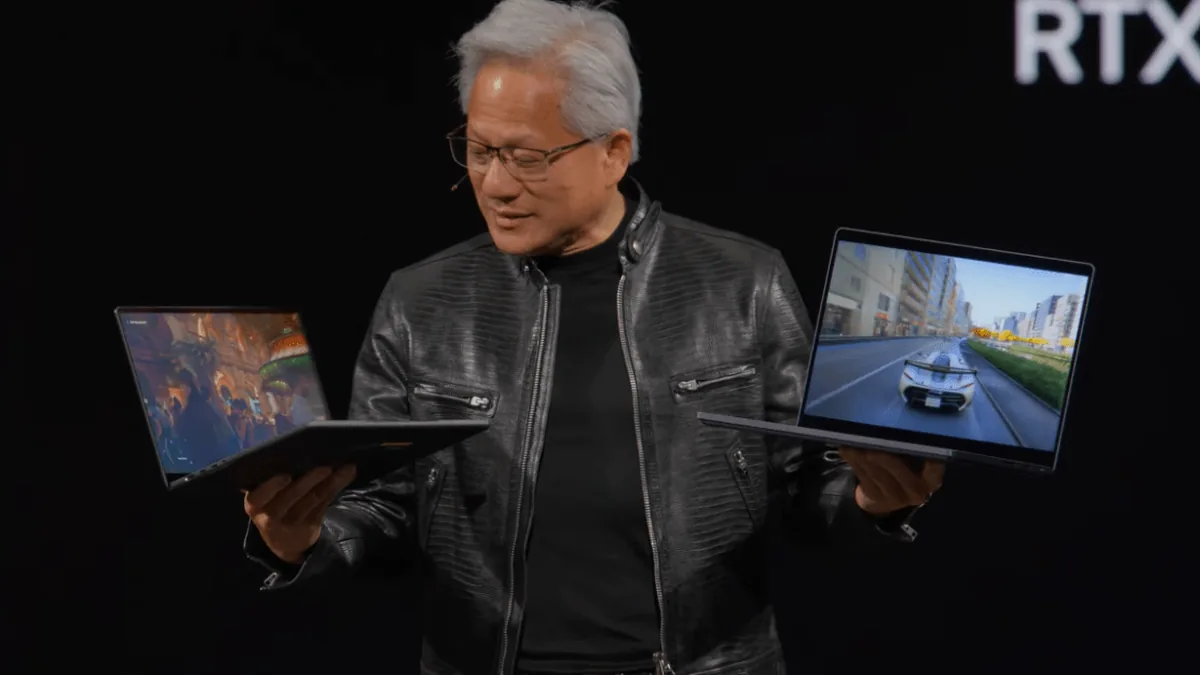 Nvidia CEO Jensen Huang holds up two RTX Spark laptops at Computex 2026